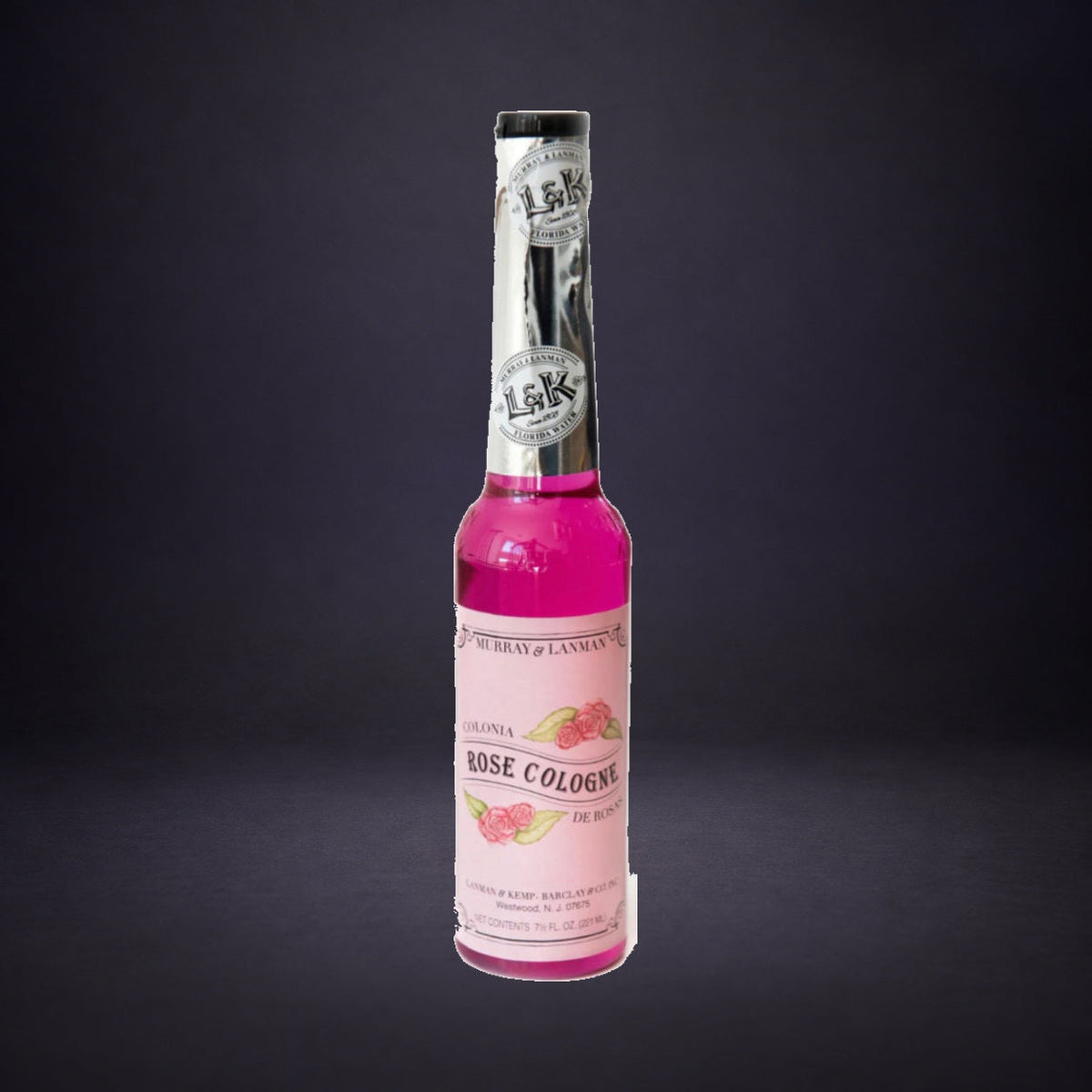Rose spiritual cologne bottle on charcoal and purple.