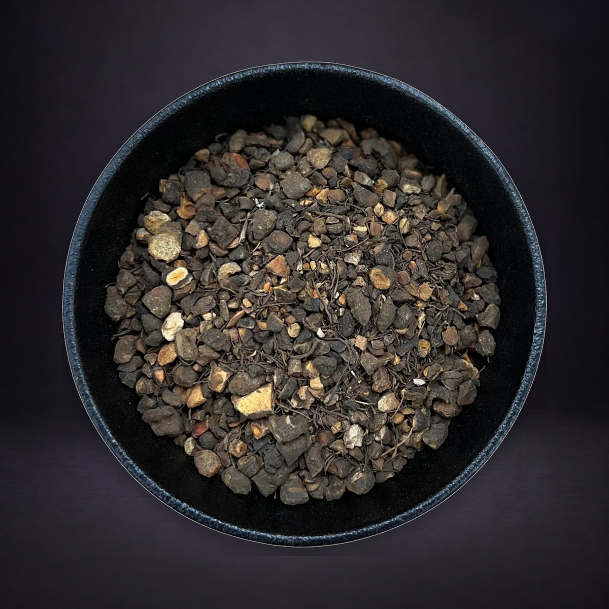 Bloodroot in its black bowl on a matte charcoal and subtle royal-purple background.